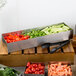 A Tablecraft stainless steel rectangular bowl filled with vegetables on a wooden table.