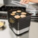 A person using a Weston food dehydrator to make cookies.
