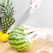 A person using a Choice chef knife to cut a watermelon.