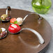 A Bon Chef mahogany lazy susan turntable with spoons and food on it.