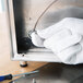 A person wearing Cordova heavy weight white gloves repairs a metal box using a screwdriver.