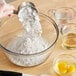 A person pouring ADM All Purpose Unbleached Flour into a bowl.