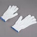 A pair of white Cordova work gloves with blue trim.