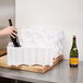 A hand placing a wine bottle in a Polar Tech white foam block.