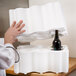 A man using a Polar Tech Safeway white foam wine shipper to hold a bottle of wine.