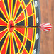 A black Arachnid striped soft tip dart in the center of a dart board.