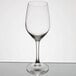 An empty Arcoroc wine glass on a reflective surface.