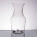 A clear plastic wine carafe on a table.