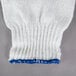 A white knitted glove with blue trim at the wrist.
