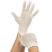 A pair of hands wearing Cordova natural polyester/cotton work gloves.