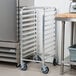 An unassembled aluminum Regency steam table pan rack with wheels.