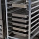 An unassembled Regency aluminum steam table pan rack holding 10 pans.