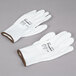 A pair of extra large white Cordova warehouse gloves with white palm coating.