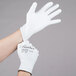 A person's hands wearing Cordova Halo white gloves with white polyurethane palm coating.