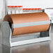 A Bulman Deluxe all-in-one paper dispenser / cutter holding a roll of brown paper.