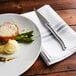 A plate of food with a Walco Erie steak knife and fork.