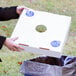 A person holding a white box with a hole in the middle.