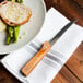 A plate of meat with a Walco steak knife and napkin.
