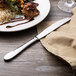 A plate of food with a Walco Lancer stainless steel knife and napkin.