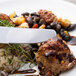 A plate of food with a Walco Lancer stainless steel dinner knife next to a fork.