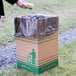 A person putting trash in a Lavex cardboard container.