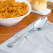 A bowl of rice with a Walco stainless steel serving spoon on a table.