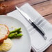 A plate of food with a Walco Parisian steak knife on it.