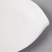 A close-up of a Villeroy & Boch white porcelain flat plate with a curved edge.