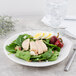 A white Villeroy & Boch porcelain plate with a spinach salad, eggs, and chicken.