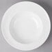 A Villeroy & Boch white porcelain pasta plate with a white rim on a gray surface.