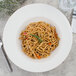 A Villeroy & Boch white porcelain pasta plate with noodles and vegetables on it.