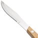 A Walco stainless steel steak knife with a Pakka wood handle.