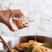 A person pouring Admiration white cooking wine into a pan.