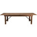 A Flash Furniture Hercules long brown wooden farm table with legs.