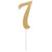 A gold glittery "7" cake topper on a white stick.