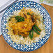 An Arcoroc Candour Azure porcelain brunch plate with a plate of chicken, rice, and green beans on a wood surface.