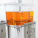 A Crathco refrigerated beverage dispenser bowl assembly with orange liquid inside.