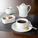 A white rectangular porcelain sugar bowl on a table with a cup of coffee and a teapot.