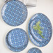 A group of white porcelain Arcoroc B&B plates with blue floral designs.