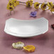 A close-up of a white CAC rectangular tasting platter with yellow flowers.