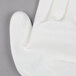 A close up of a Cordova Mirage white glove with a white polyurethane palm coating.