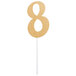 A gold glittery number 8 cake topper.