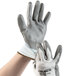 A pair of large Cordova Caliber white warehouse gloves with gray polyurethane palm coating on a hand.