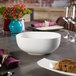 A white Villeroy & Boch Urban Nature salad bowl on a table with wine glasses.