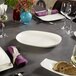 A table set with Villeroy & Boch white oval platters, plates, and glasses.