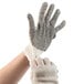 A hand wearing a Cordova economy weight work glove with black PVC dots.