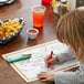 A child coloring on a Hoffmaster Jungle Fun placemat.