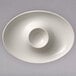 A white oval porcelain bowl with a round hole in the middle.