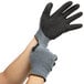 A pair of hands wearing Cordova gray warehouse gloves with black latex crinkle palms.