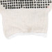 A close-up of Cordova white and black knitted gloves with black dots.